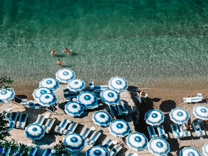Positano beach on the Amalfi Coast Italy . European summer and long hot summer beach days under striped parasols and refreshing swims in the Mediterranean sea.